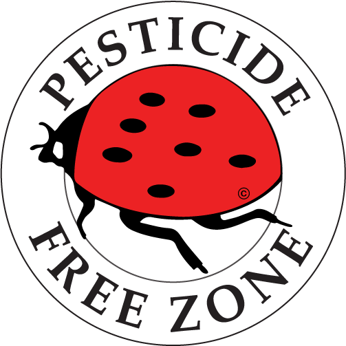 A circular sign with a red ladybug at the center and the words "PESTICIDE FREE ZONE" written around it in black capital letters on a white background.